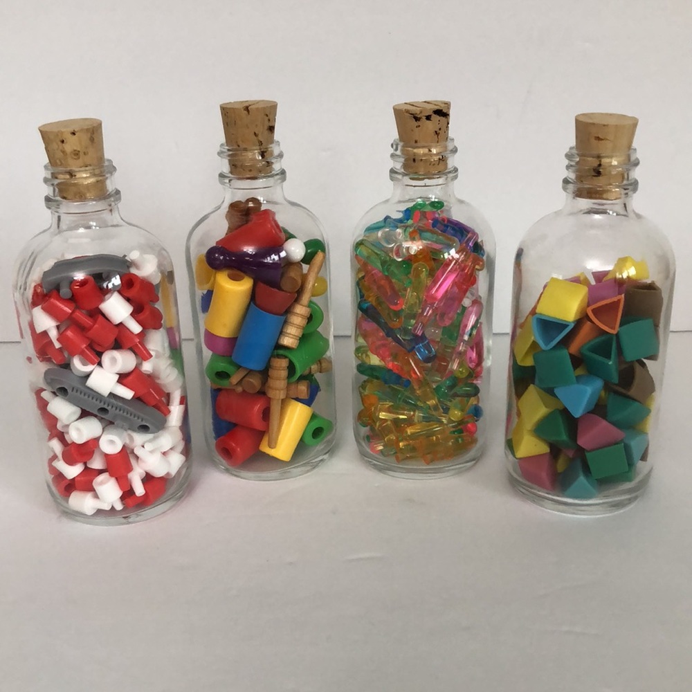 Game Pieces In Glass Jars With Corks